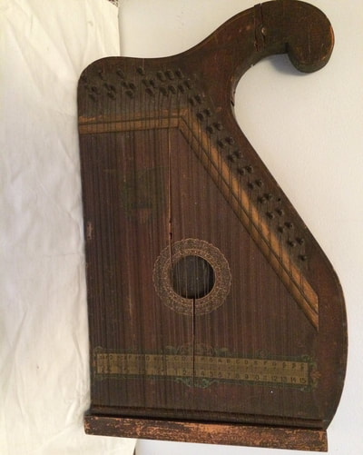 Antique wooden zither, early 1920s. Manufactured by the International Music Corporation in Hoboken, NJ, which made musical instruments.  Strings are intact but not playable due to wood damage  21" X 13" X 2"
